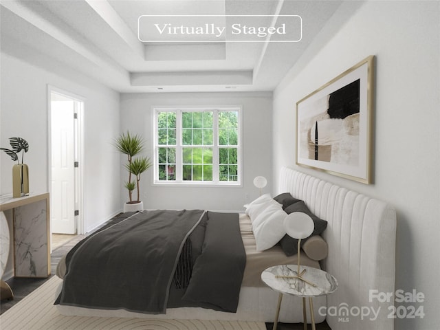 bedroom featuring wood-type flooring and a raised ceiling