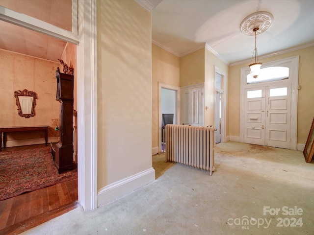 entryway featuring crown molding, radiator heating unit, wood-type flooring, and vaulted ceiling