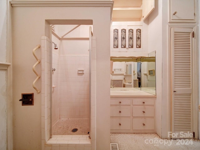 bathroom featuring a tile shower and vanity