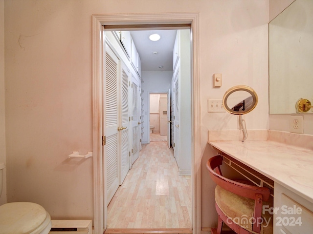 bathroom with vanity, wood-type flooring, and toilet