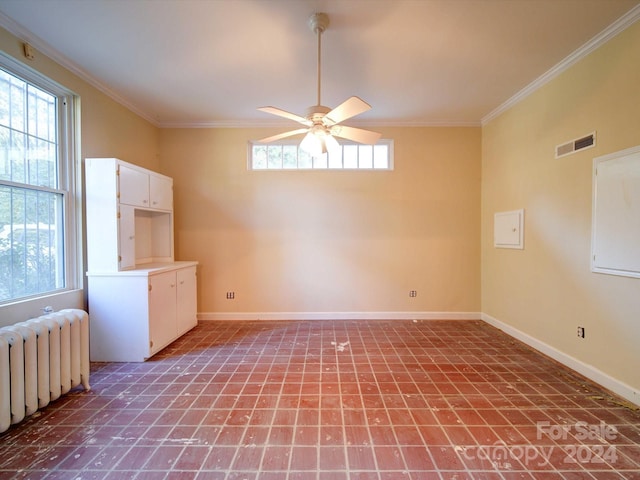 unfurnished room with radiator, ceiling fan, ornamental molding, and plenty of natural light