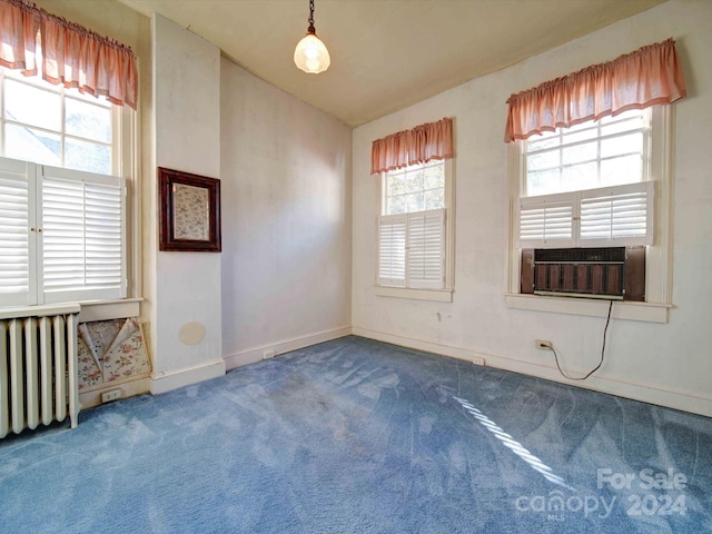 empty room featuring carpet, cooling unit, and radiator heating unit