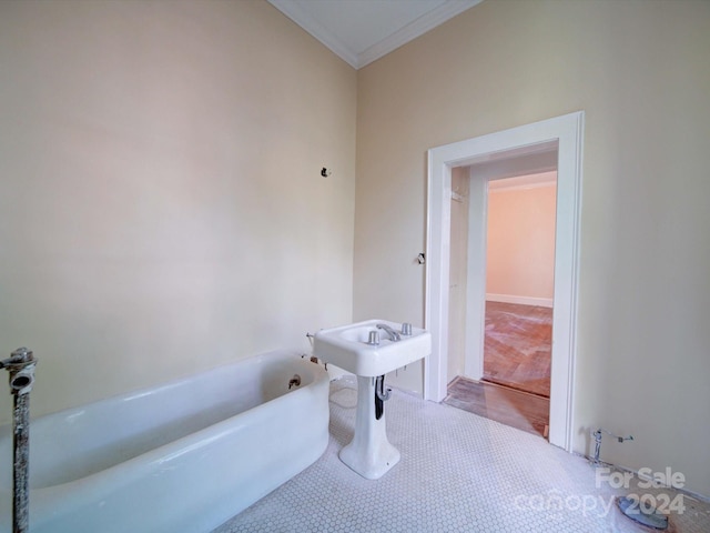 bathroom with crown molding, hardwood / wood-style flooring, and a bathing tub