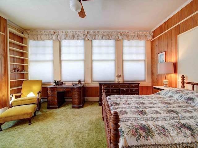 carpeted bedroom with ceiling fan, multiple windows, and wood walls