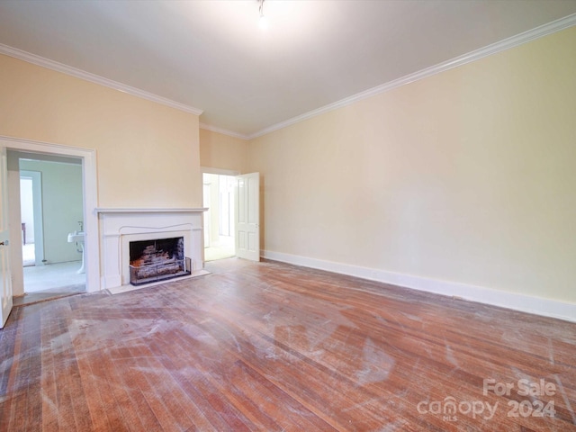 unfurnished living room featuring hardwood / wood-style floors and crown molding