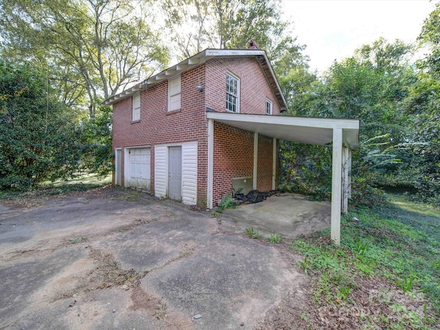 view of side of home with a garage and a carport