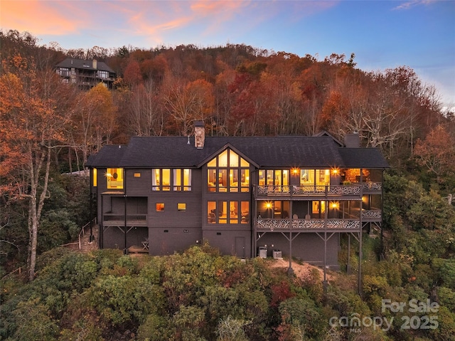 back house at dusk with a wooden deck