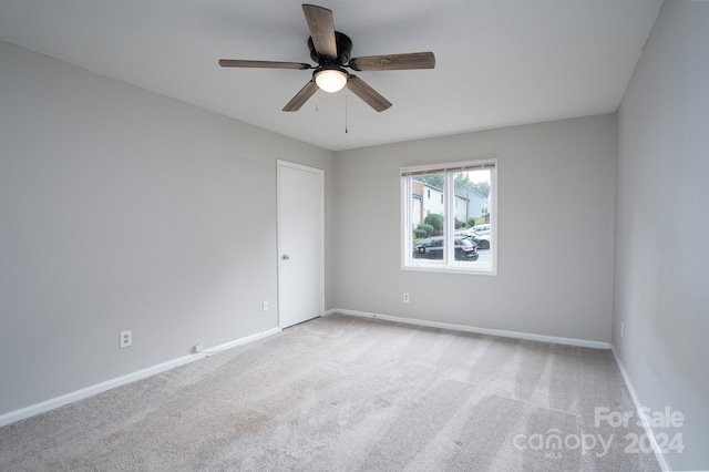 empty room with ceiling fan and light colored carpet