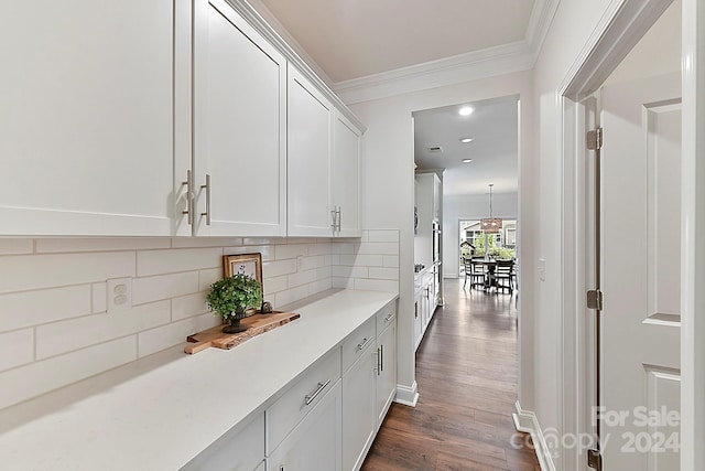 interior space featuring decorative backsplash, crown molding, dark hardwood / wood-style flooring, and white cabinets