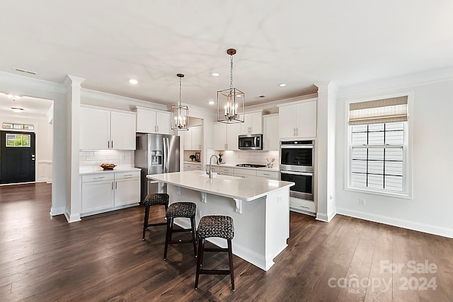 kitchen featuring white cabinetry, appliances with stainless steel finishes, plenty of natural light, and dark wood-type flooring