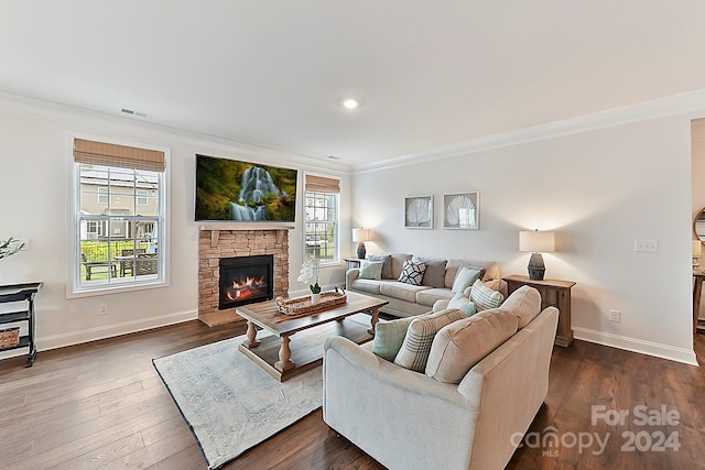 living room featuring a stone fireplace, ornamental molding, and dark hardwood / wood-style flooring