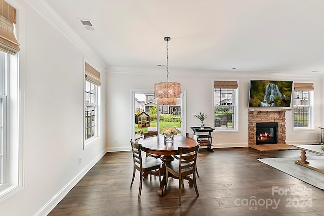 dining space featuring crown molding, a fireplace, dark hardwood / wood-style flooring, and plenty of natural light