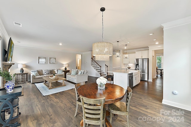 dining room with a notable chandelier, crown molding, dark hardwood / wood-style flooring, and sink