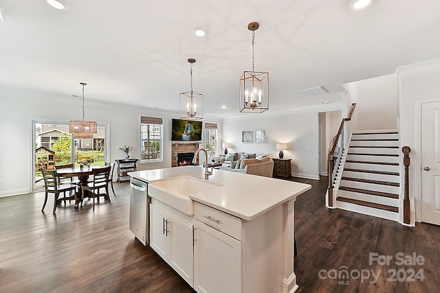 kitchen featuring white cabinets, dark hardwood / wood-style flooring, decorative light fixtures, a kitchen island with sink, and sink