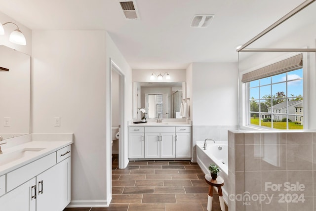 full bathroom featuring independent shower and bath, vanity, and toilet