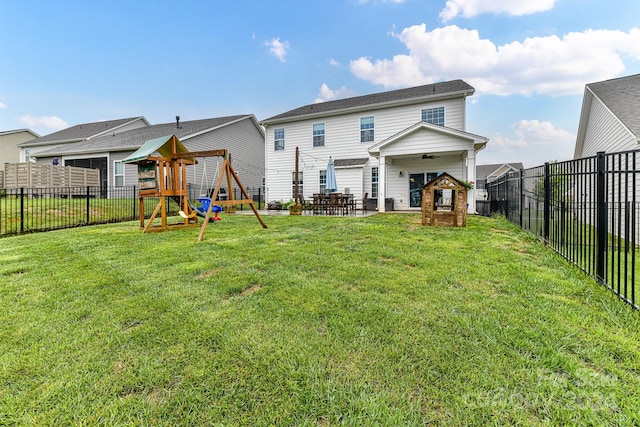 back of house with a playground, a lawn, and a patio area