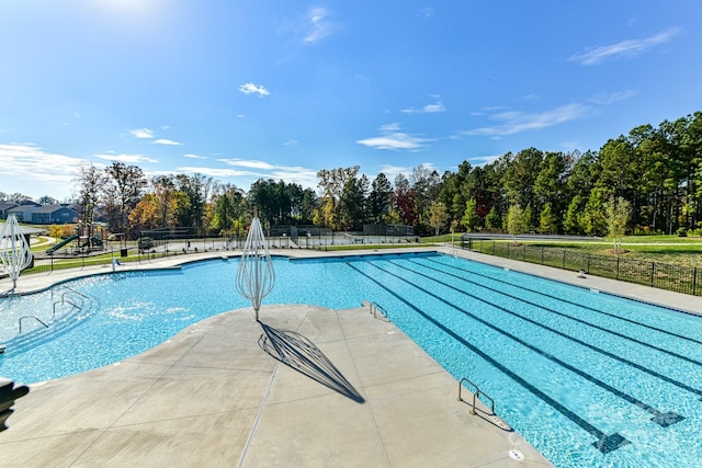 view of pool featuring a playground and a patio area