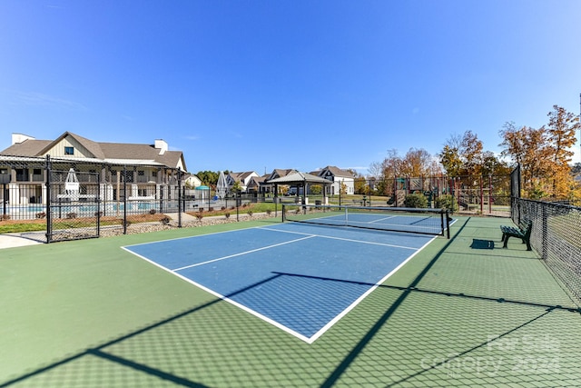 view of tennis court featuring a fenced in pool