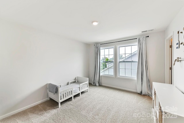 bedroom with light carpet, visible vents, and baseboards