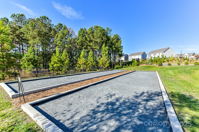 view of property's community with a lawn, fence, and a residential view