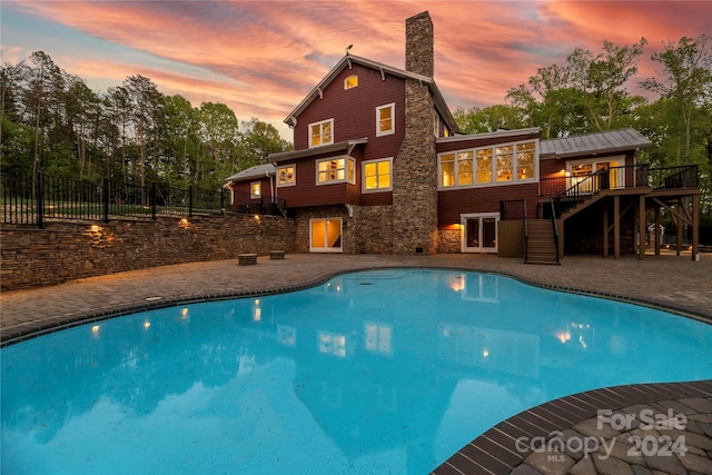 pool at dusk with a deck