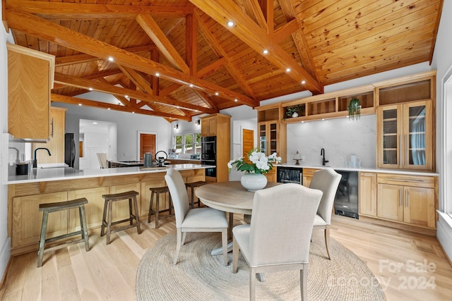 dining area with wine cooler, sink, light hardwood / wood-style flooring, lofted ceiling with beams, and wooden ceiling