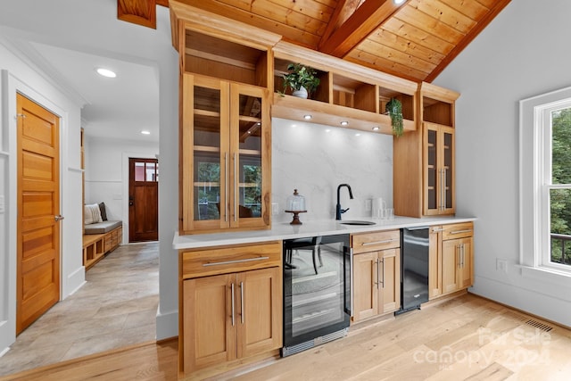 bar with light hardwood / wood-style floors, wooden ceiling, beverage cooler, vaulted ceiling with beams, and plenty of natural light