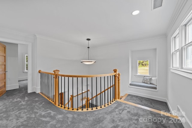 hallway featuring ornamental molding and dark colored carpet