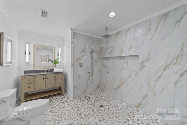 bathroom with a tile shower, vanity, crown molding, and toilet