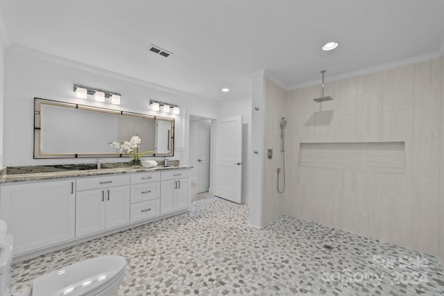 bathroom with ornamental molding, tiled shower, vanity, and toilet