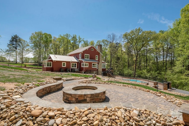 rear view of house featuring a fire pit and a patio area