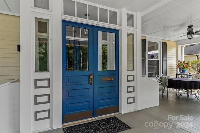 entrance to property featuring ceiling fan and covered porch