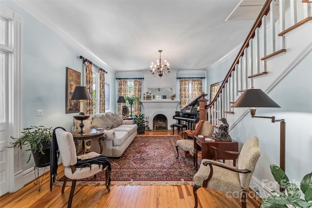 404 Avery Ave, Morganton, NC 28655 - living room with stairway, a chandelier, wood-type flooring, ornamental molding, and a fireplace with raised hearth