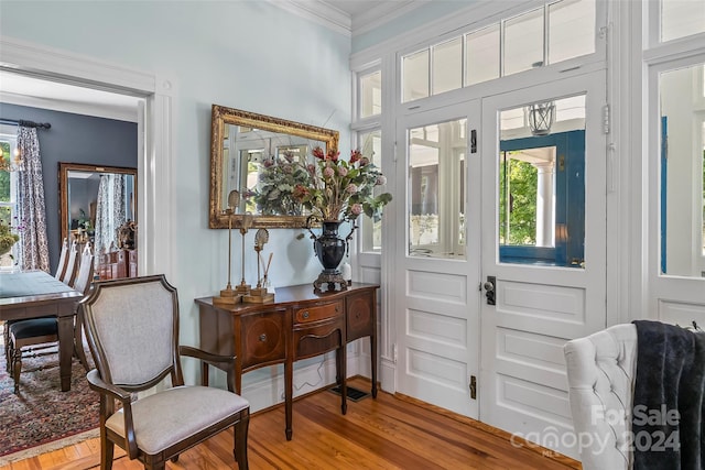 foyer entrance featuring a wealth of natural light, light hardwood / wood-style floors, and crown molding