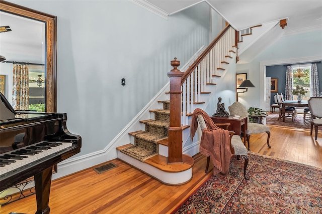 stairway featuring ornamental molding and hardwood / wood-style floors