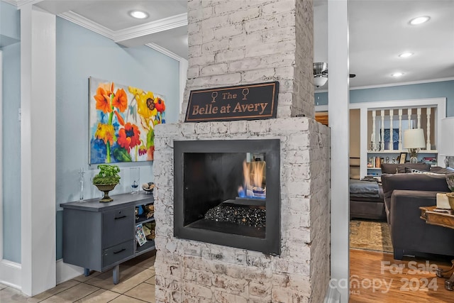 living room with a multi sided fireplace, crown molding, and light tile patterned floors