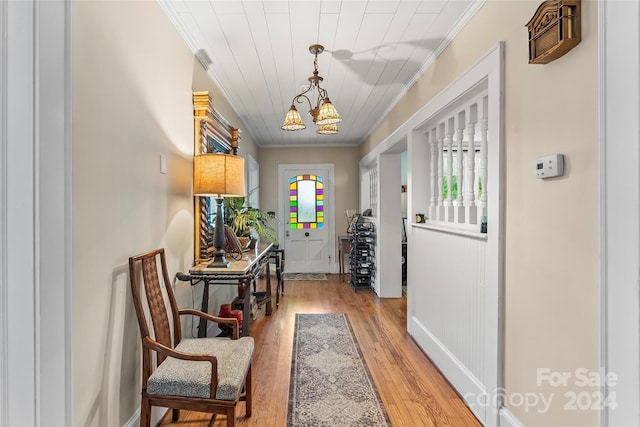 entrance foyer featuring an inviting chandelier, light hardwood / wood-style flooring, and ornamental molding