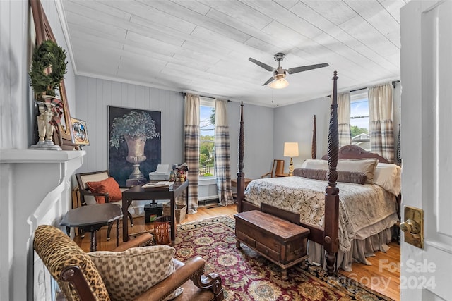 bedroom featuring ceiling fan, ornamental molding, light hardwood / wood-style floors, and multiple windows