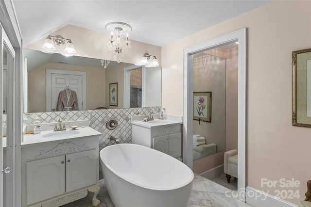 404 Avery Ave, Morganton, NC 28655 - bathroom with a freestanding tub, two vanities, marble look tiles, vaulted ceiling, and a chandelier