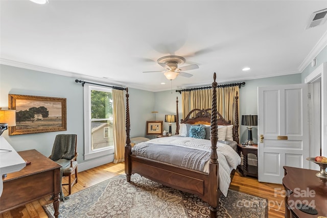 bedroom with light hardwood / wood-style flooring, ceiling fan, and ornamental molding