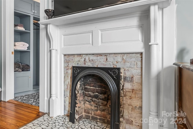 room details featuring wood-type flooring, a fireplace, and built in shelves