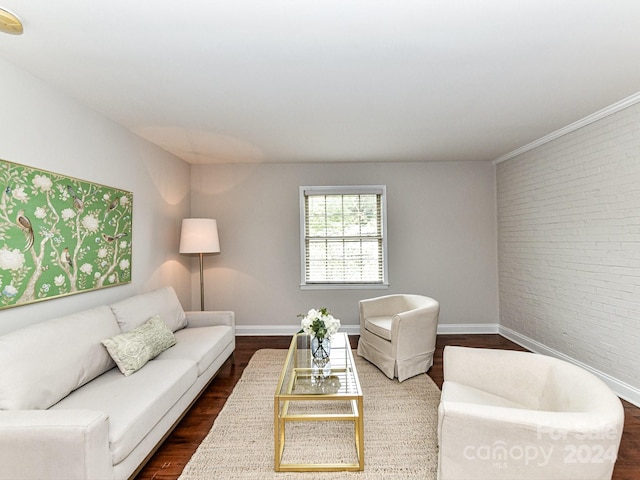 living room with brick wall, ornamental molding, and dark wood-type flooring