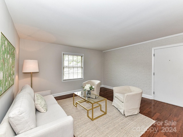 living room featuring brick wall and hardwood / wood-style flooring