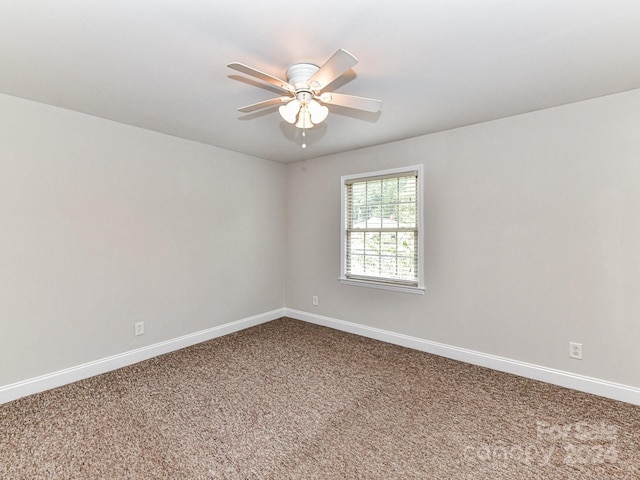 empty room featuring ceiling fan and carpet