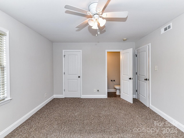 unfurnished bedroom featuring ceiling fan, ensuite bathroom, and carpet flooring