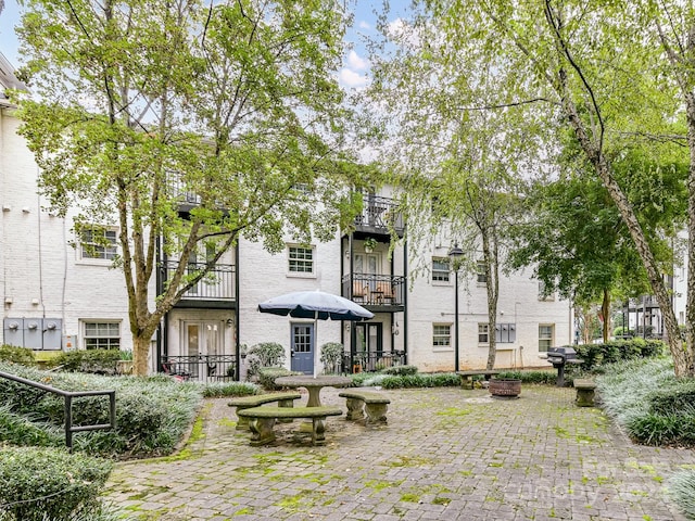 back of property featuring a balcony and a patio area