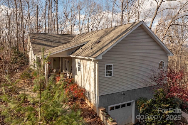 view of property exterior featuring covered porch and a garage