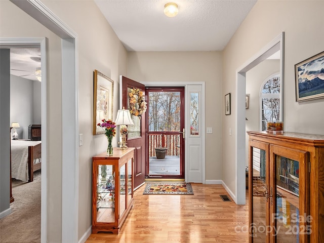 entryway featuring light wood-type flooring and a textured ceiling