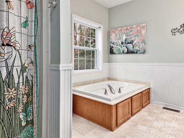 bathroom featuring tile patterned floors and a tub to relax in