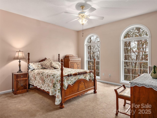 bedroom featuring multiple windows, ceiling fan, and light colored carpet